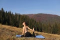 Young fit woman doing exercises on yoga mat on background of sunny mountains hills. Outdoor workout, healthy lifestyle. female in Royalty Free Stock Photo