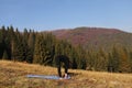 Young fit woman doing exercises on yoga mat on background of sunny mountains hills. Outdoor workout, healthy lifestyle. female in Royalty Free Stock Photo