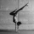 Young fit woman doing handstand exercise in studio. Royalty Free Stock Photo