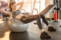 Young fit woman doing sit-ups on exercise ball in gym Royalty Free Stock Photo