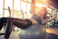 Young fit woman doing sit-ups on exercise ball in gym Royalty Free Stock Photo