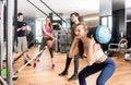 Young fit woman doing squats exercise while holding a heavy sandbag