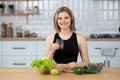 Young fit woman holds a glass of clean water, smiling in home kitchen. Female follow healthy lifestyle. Healthy diet eating Royalty Free Stock Photo