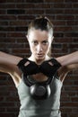 Young fit woman lifting kettle bell and looking at camera Royalty Free Stock Photo