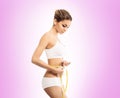 Young and fit woman measuring her waist with a tape Royalty Free Stock Photo
