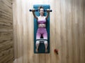 Young fit woman in pink sportswear lying on her exercise mat working out with dumbbells and elastic band Royalty Free Stock Photo