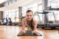 Young fit woman practicing the forearm plank exercise for core s