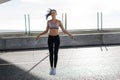 Young fit woman skipping with a jump rope in the city