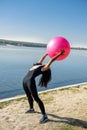 Young fit woman in sportswear during fitness time and exercising with ball at the lake. Healthy lifestyle Royalty Free Stock Photo