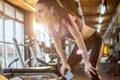 Young fit woman in sportswear holding smart phone and listing to music via earphones during exercise break in gym. Royalty Free Stock Photo