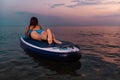 Young fit woman in swimsuit posing with a sup board. Back view. Concept of summer vacation and water sport Royalty Free Stock Photo