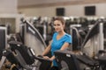 Young fit woman using a bicycle in a fitness center, cardio. Portrait of fitness girl in the gym, lifestyle concept. Royalty Free Stock Photo