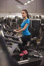 Young fit woman using a bicycle in a fitness center, cardio. Portrait of fitness girl in the gym, lifestyle concept.. Royalty Free Stock Photo