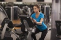 Young fit woman using a bicycle in a fitness center, cardio. Portrait of fitness girl in the gym, lifestyle concept. Royalty Free Stock Photo