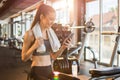 Young fit woman using smart phone at gym Royalty Free Stock Photo