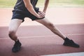 Young fitness athlete man running on road track, exercise workout wellness and runner stretching legs before run concept Royalty Free Stock Photo