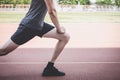 Young fitness athlete man running on road track, exercise workout wellness and runner stretching legs before run concept Royalty Free Stock Photo