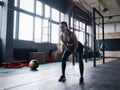 Young fitness female exercise with kettle bell. Caucasian woman doing crossfit workout at gym.