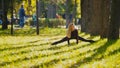 Young fitness female model Exercising in a Meadow at autumn park, Sports Outdoor Activities concept - flexibility Royalty Free Stock Photo