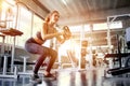 young fitness girl doing exercise squat with weight barbell plat