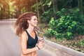 Young fitness girl running and listening music in the park