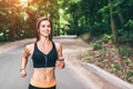 Young fitness girl running and listening music in the park Royalty Free Stock Photo