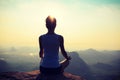 Fitness woman meditating on sunrise mountain peak Royalty Free Stock Photo