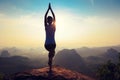 Fitness woman meditating on sunrise mountain peak Royalty Free Stock Photo