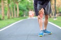 Young fitness man holding his sports leg injury. muscle painful during training. Asian runner having knee ache and problem after Royalty Free Stock Photo