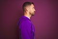 Young fitness man wearing casual sports sweatshirt over purple isolated background looking to side, relax profile pose with Royalty Free Stock Photo