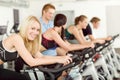 Young fitness people bike spinning with instructor Royalty Free Stock Photo