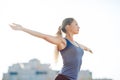 Young fitness woman in a blue shirt and leggings smile spread her hands to the sky for success in waiting the sun shines in her fa