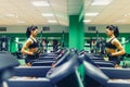 Young fitness woman doing cardio exercises at the gym running on a treadmill female runner training at the gim.