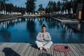 Young fitness woman doing her morning yoga near the pool Royalty Free Stock Photo