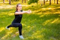 Young fitness woman doing lunges exercises to train leg muscles. An active girl does an exercise with a lunge on one leg in front