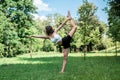 Young fitness woman doing practicing yoga or pilates exercise on green grass at park Royalty Free Stock Photo