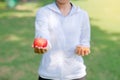 Young fitness woman holding in hands red apple and donut