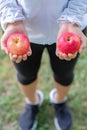 Young fitness woman holding in hands red apple