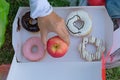 Young fitness woman holding in hands red apple and donut