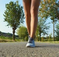 Young fitness woman legs running on asphalt road Royalty Free Stock Photo