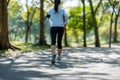 Young fitness woman legs walking in the park outdoor, female runner running on the road outside, asian athlete jogging and exercis Royalty Free Stock Photo