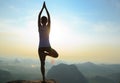 Woman meditating on sunrise mountain peak Royalty Free Stock Photo