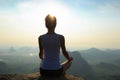 Woman meditating on sunrise mountain peak Royalty Free Stock Photo