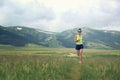 Young fitness woman runner running on grassland