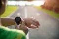 Young fitness woman runner setting up smart watch before running training during sunset. Outdoor exercise activities concept Royalty Free Stock Photo