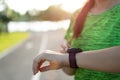 Young fitness woman runner setting up smart watch before running training during sunset. Outdoor exercise activities concept Royalty Free Stock Photo