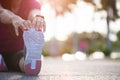 Young fitness woman runner sit on the road stretching legs before run in the park. Outdoor exercise activities concept Royalty Free Stock Photo