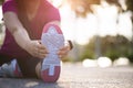 Young fitness woman runner sit on the road stretching legs before run in the park. Outdoor exercise activities concept Royalty Free Stock Photo