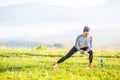 Young fitness woman runner stretching legs before run in autumn nature Royalty Free Stock Photo