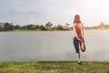 Young fitness woman runner stretching legs before run on park. Royalty Free Stock Photo